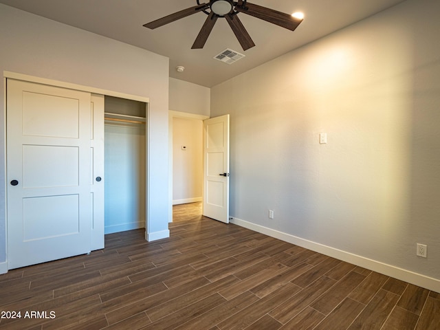 unfurnished bedroom with a closet, dark hardwood / wood-style floors, and ceiling fan