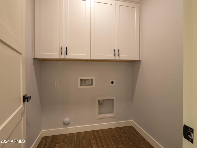 washroom featuring electric dryer hookup, dark wood-type flooring, cabinets, and washer hookup