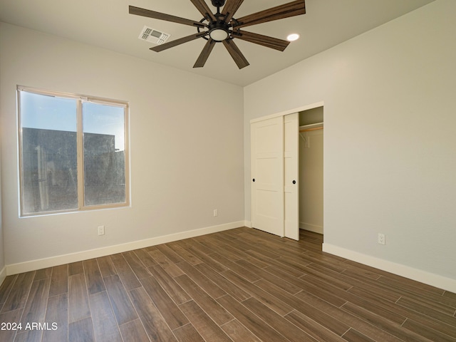 unfurnished bedroom with ceiling fan, dark wood-type flooring, and a closet