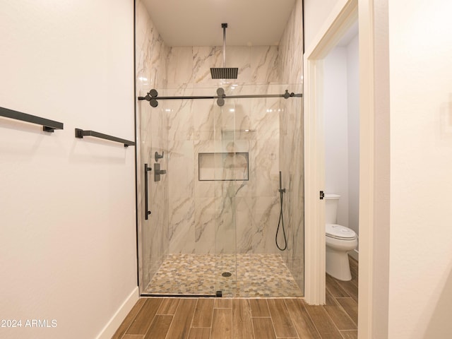 bathroom with an enclosed shower and toilet