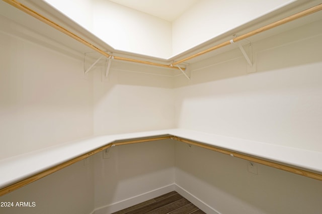 walk in closet with dark wood-type flooring