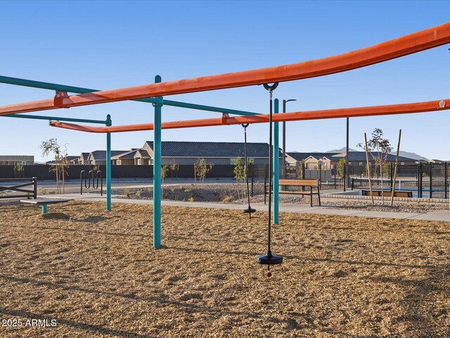 community jungle gym featuring a residential view and fence