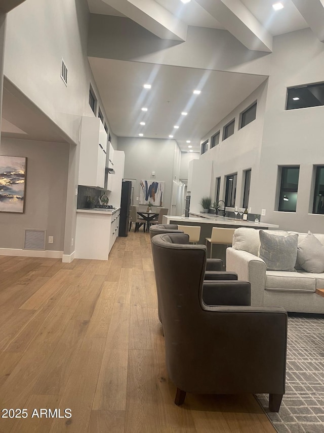 living room featuring light hardwood / wood-style flooring and a high ceiling