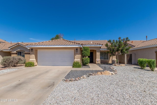 ranch-style home featuring an attached garage, driveway, a tile roof, and stucco siding