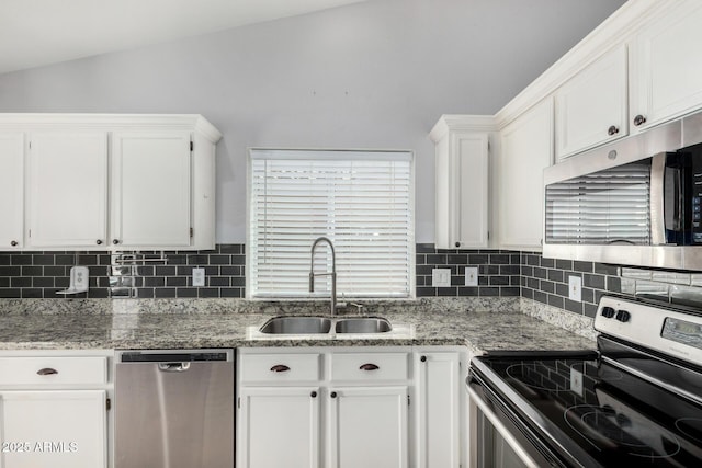 kitchen featuring white cabinets, appliances with stainless steel finishes, a sink, and tasteful backsplash