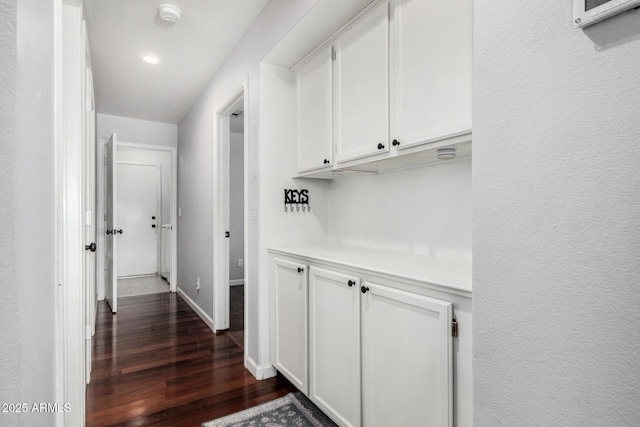 hall featuring recessed lighting, baseboards, and dark wood-style floors