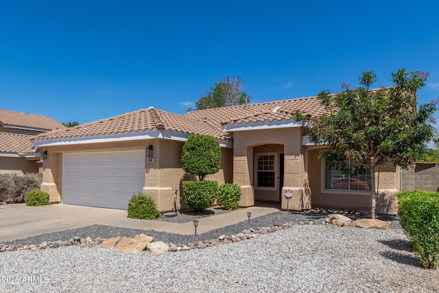 view of front of house featuring a garage, stucco siding, a tiled roof, and concrete driveway