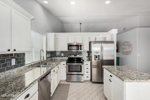 kitchen featuring a sink, decorative backsplash, vaulted ceiling, and stainless steel appliances