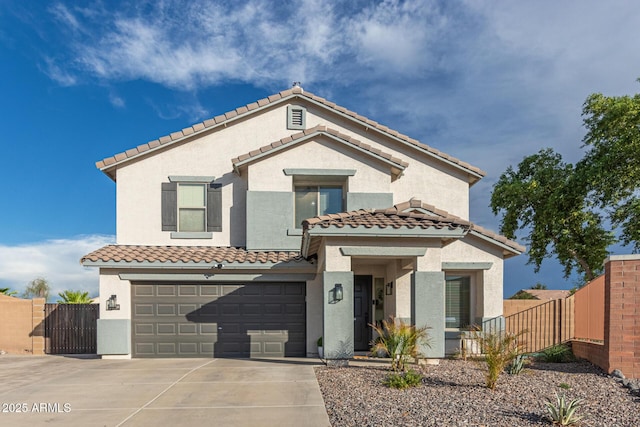 mediterranean / spanish-style home featuring an attached garage, driveway, a tiled roof, stucco siding, and fence