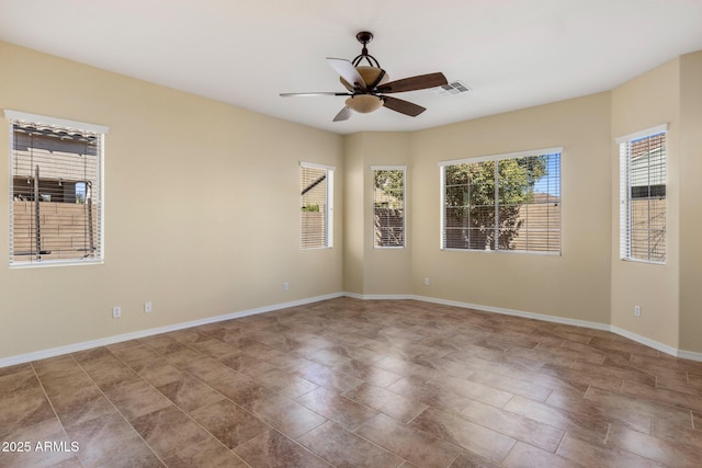 empty room featuring a wealth of natural light and ceiling fan