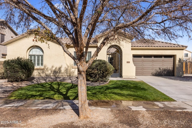 mediterranean / spanish-style house featuring a garage and a front yard