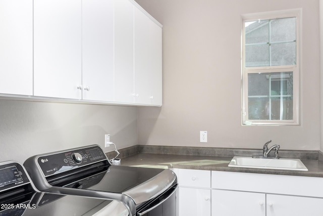 washroom with a healthy amount of sunlight, cabinet space, washer and clothes dryer, and a sink