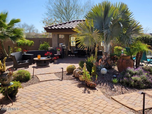 view of patio with fence, a fire pit, and area for grilling