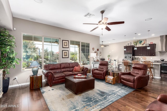 living area featuring recessed lighting, visible vents, hardwood / wood-style floors, a ceiling fan, and baseboards