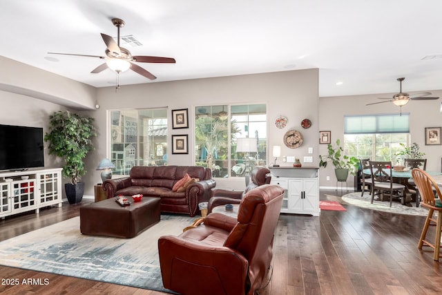 living area featuring visible vents, wood finished floors, a ceiling fan, and baseboards