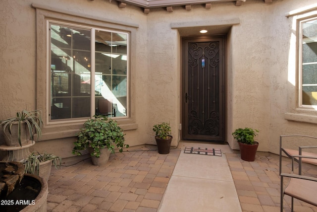 doorway to property featuring a patio and stucco siding