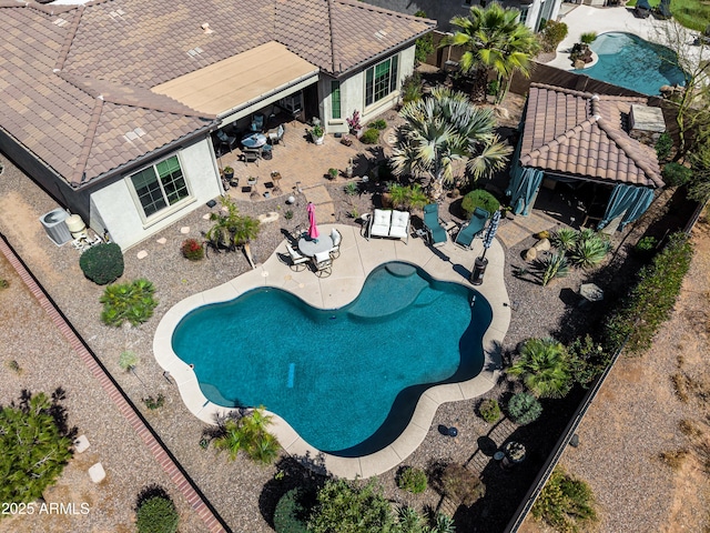 outdoor pool with a patio area and a fenced backyard