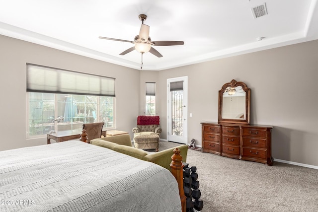 carpeted bedroom with a raised ceiling, visible vents, ceiling fan, access to outside, and baseboards