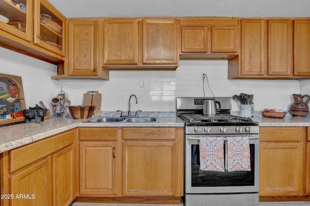 1815 E Illini St, Phoenix, AZ 85040 - kitchen with glass insert cabinets, a sink, stainless steel gas stove, and tasteful backsplash
