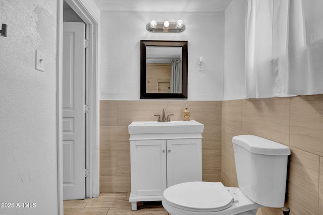 1815 E Illini St, Phoenix, AZ 85040 - bathroom with toilet, a wainscoted wall, tile walls, and vanity