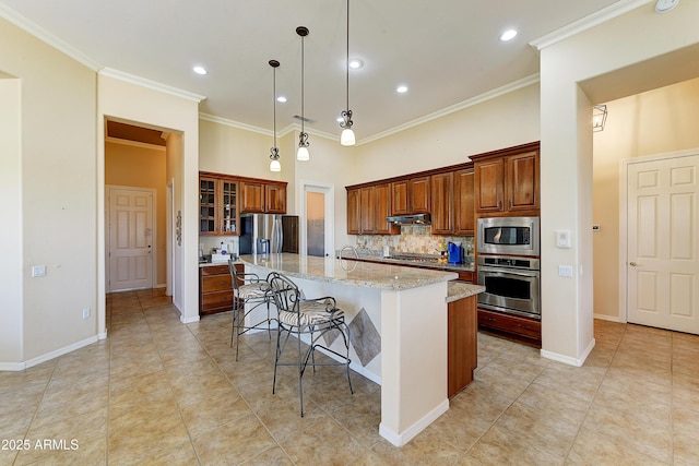 20609 N Canyon Whisper Dr, Surprise, AZ 85387 - kitchen featuring appliances with stainless steel finishes, a kitchen breakfast bar, backsplash, under cabinet range hood, and ornamental molding