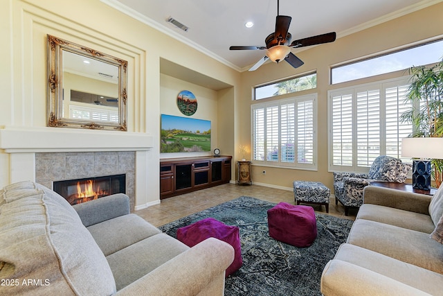 20609 N Canyon Whisper Dr, Surprise, AZ 85387 - tiled living room with a ceiling fan, visible vents, crown molding, a tile fireplace, and baseboards