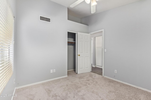 unfurnished bedroom with lofted ceiling, light carpet, ceiling fan, and a closet