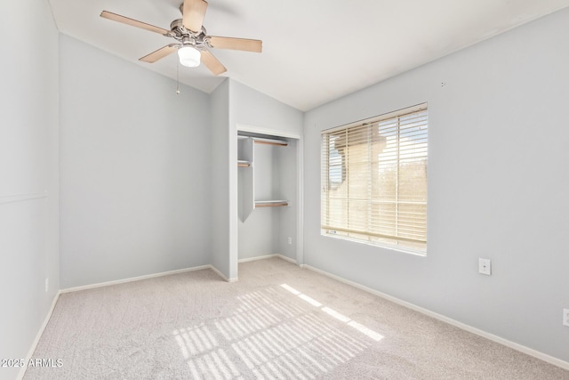 unfurnished bedroom featuring lofted ceiling, light colored carpet, a closet, and ceiling fan