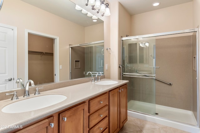 bathroom featuring vanity, a shower with shower door, and tile patterned flooring