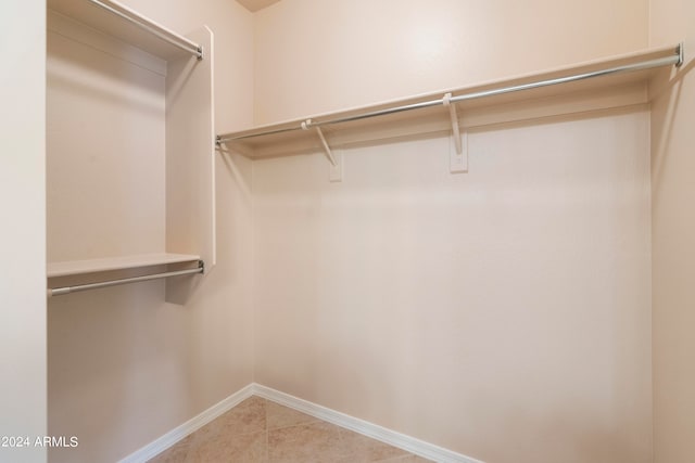 walk in closet with light tile patterned floors