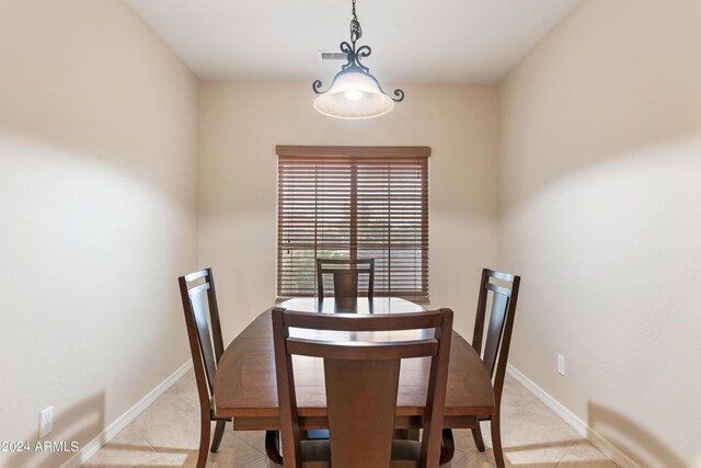 kitchen featuring light tile patterned floors, appliances with stainless steel finishes, a breakfast bar area, light stone countertops, and sink