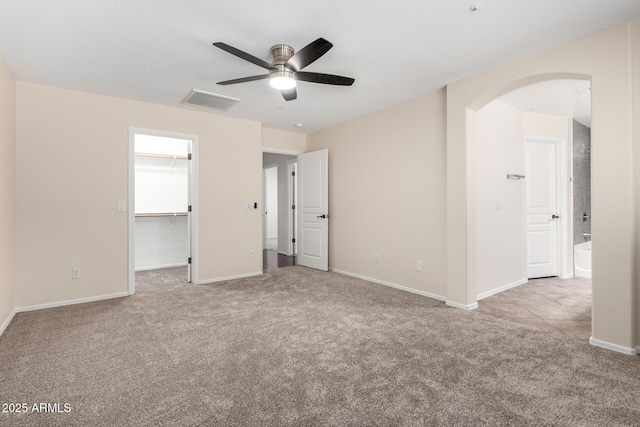 12838 W Desert Mirage Dr, Peoria, AZ 85383 - unfurnished bedroom featuring visible vents, arched walkways, baseboards, a spacious closet, and carpet flooring