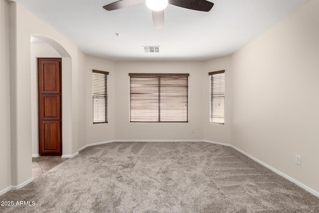 12838 W Desert Mirage Dr, Peoria, AZ 85383 - carpeted empty room with a ceiling fan, arched walkways, visible vents, and baseboards