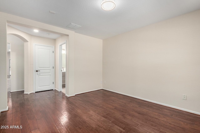 12838 W Desert Mirage Dr, Peoria, AZ 85383 - spare room featuring arched walkways, baseboards, and wood finished floors