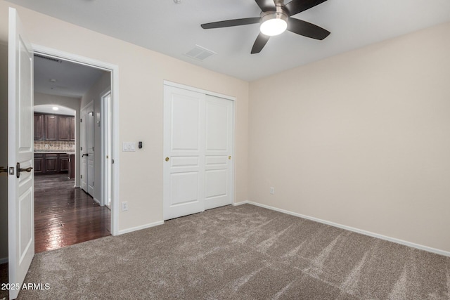 12838 W Desert Mirage Dr, Peoria, AZ 85383 - unfurnished bedroom with dark colored carpet, baseboards, visible vents, and a closet