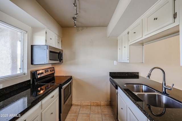 kitchen featuring white cabinetry, appliances with stainless steel finishes, sink, and dark stone countertops