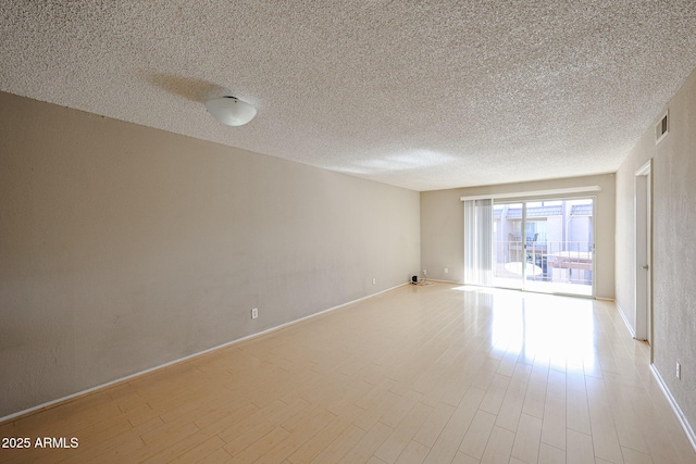 unfurnished room with a textured ceiling