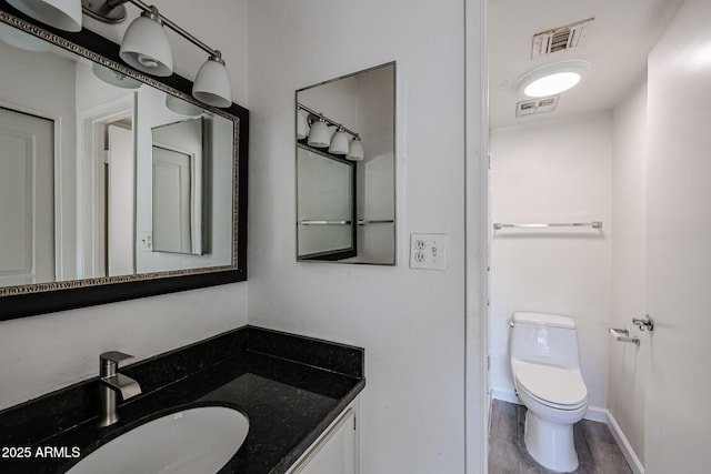 bathroom with vanity, hardwood / wood-style floors, and toilet