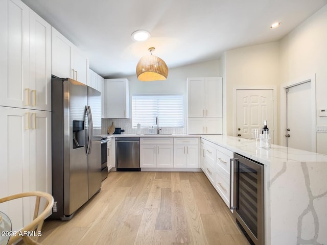 kitchen featuring sink, white cabinetry, wine cooler, and appliances with stainless steel finishes