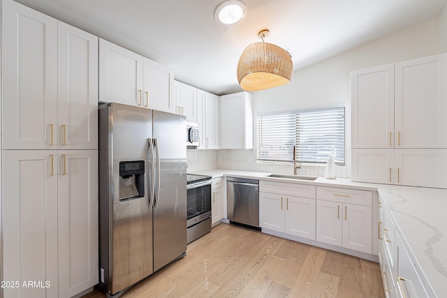 kitchen with sink, white cabinetry, appliances with stainless steel finishes, and pendant lighting