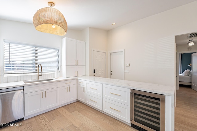 kitchen with white cabinetry, stainless steel dishwasher, sink, pendant lighting, and wine cooler