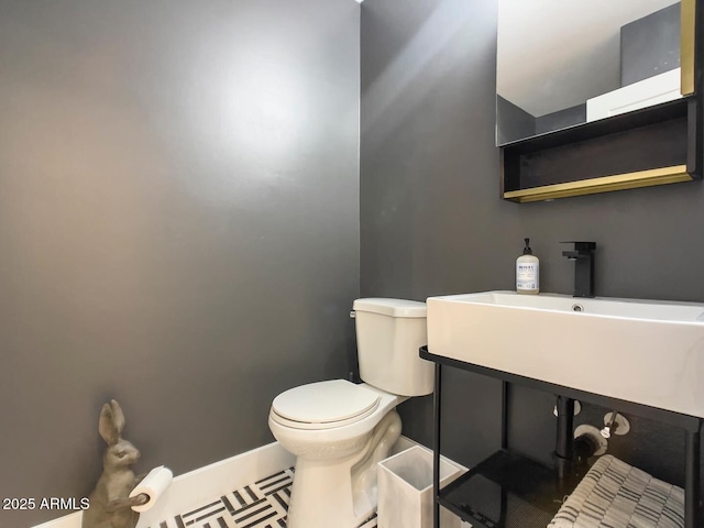 bathroom with sink, toilet, and tile patterned flooring