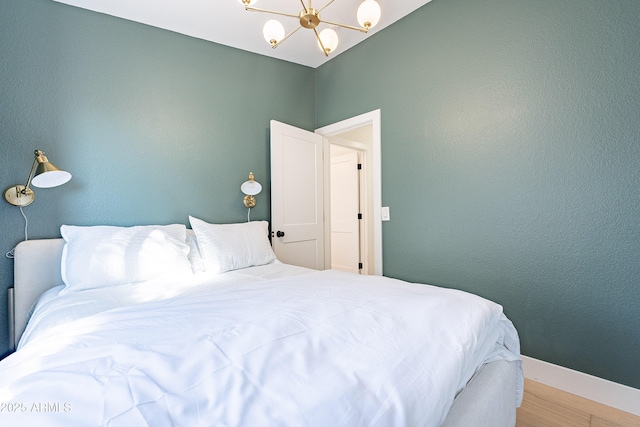 bedroom featuring hardwood / wood-style flooring and a chandelier