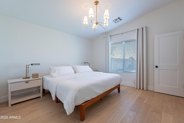 bedroom featuring lofted ceiling, a notable chandelier, and light wood-type flooring