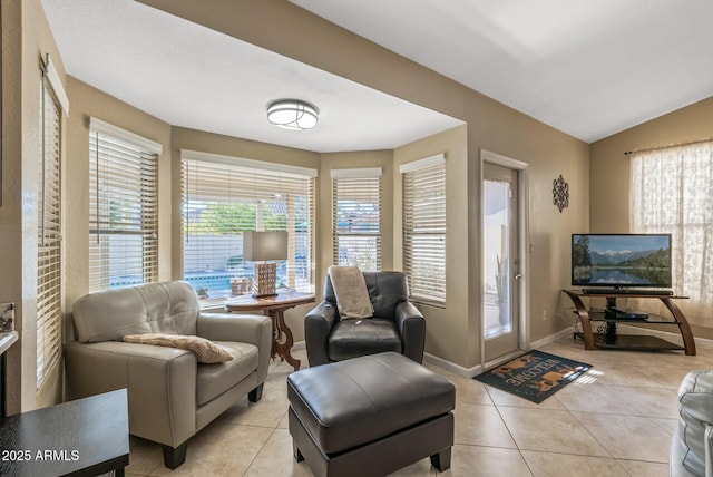 living area with light tile patterned floors and vaulted ceiling