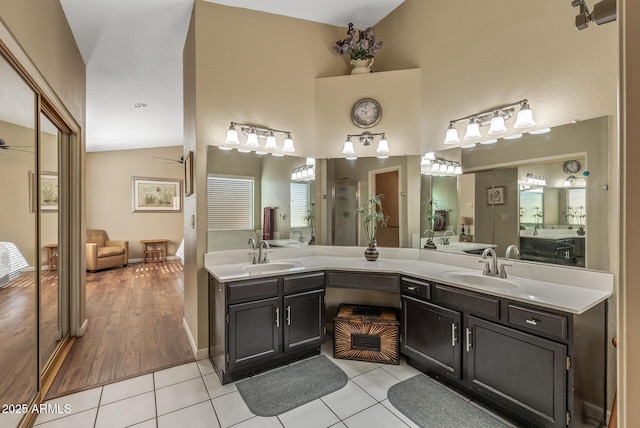 bathroom with vaulted ceiling, ceiling fan, tile patterned flooring, and vanity