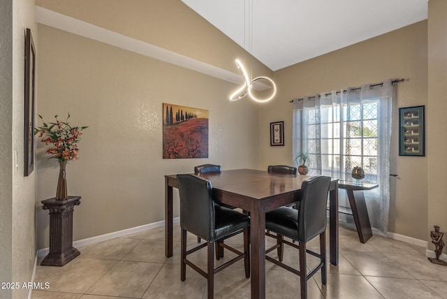 tiled dining space featuring vaulted ceiling