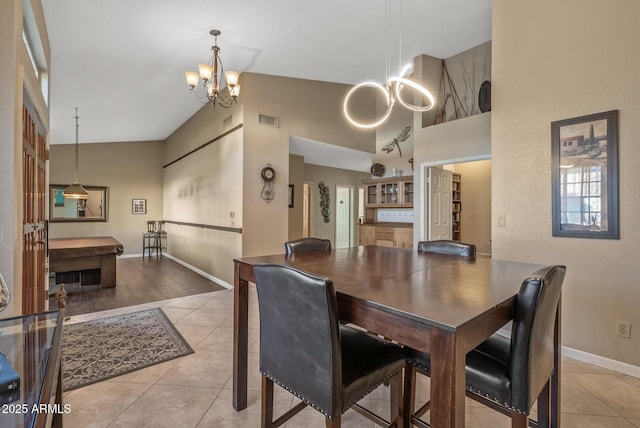 dining room featuring high vaulted ceiling, light tile patterned floors, and a chandelier