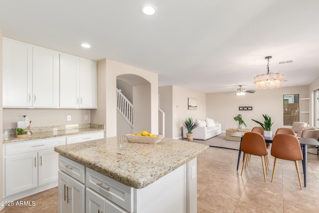 kitchen with white cabinetry, recessed lighting, open floor plan, and a center island