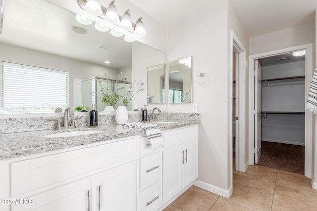 bathroom with tile patterned flooring, visible vents, a shower stall, and a sink